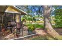 Patio view of home featuring pond, green lawn and outdoor dining set under a shady tree at 238 Southampton Dr # 319, Venice, FL 34293
