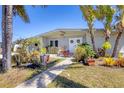Attractive single-story home with a garden and lush tropical landscaping, creating a warm welcome at 301 Palmetto Ne Dr, Port Charlotte, FL 33952