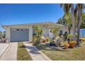 Inviting single-story home with a well-manicured lawn and tropical landscaping, plus a convenient garage at 301 Palmetto Ne Dr, Port Charlotte, FL 33952