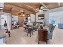 Cozy living room featuring a unique wood ceiling, neutral tile floors, and comfortable seating arrangements at 301 Palmetto Ne Dr, Port Charlotte, FL 33952