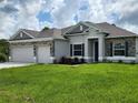 Attractive home featuring a three-car garage, stone facade, and lush green lawn at 354 Porto Alegre St, Punta Gorda, FL 33983