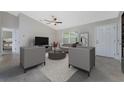 Bright and airy living room featuring modern furnishings, neutral decor, and a ceiling fan for added comfort at 481 Starborn St, Port Charlotte, FL 33954