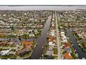 This aerial view showcases the waterfront neighborhood with canals and boat access to a wide bay at 548 Belvedere Ct, Punta Gorda, FL 33950