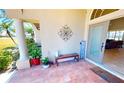 Inviting front porch with tiled flooring, decorative columns, cozy seating, and a 'Home Sweet Home' welcome sign at 569 Royal Poinciana, Punta Gorda, FL 33955