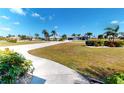 A street view showcases the well-manicured lawns and lush landscaping enhancing this neighborhood's curb appeal at 569 Royal Poinciana, Punta Gorda, FL 33955