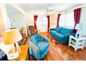 Cozy living room with wood floors, blue sofa and ample natural light from the windows at 6821 Ocean Ct # Lot 30, North Port, FL 34287