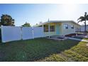 This single-story home has a fenced-in yard with a walkway leading to the front door and carport at 824 Conreid Ne Dr, Port Charlotte, FL 33952