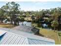 Backyard view featuring a screened pool enclosure and canal access with private dock at 908 Tropical Nw Cir, Port Charlotte, FL 33948