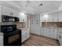Well-lit kitchen featuring white cabinets, granite countertops, stainless steel appliances and tile backsplash at 908 Tropical Nw Cir, Port Charlotte, FL 33948