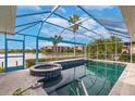Enclosed pool and spa overlooking a serene lake, offering a private and relaxing outdoor oasis at 103 Colony Point Dr, Punta Gorda, FL 33950