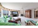 Bright living room with a fireplace, patterned furniture, and access to screened outdoor patio at 11000 Placida Rd # 1501, Placida, FL 33946