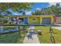 Charming home with an eclectic front yard, inviting curb appeal and vibrant colors at 131 Buckeye Nw Ave, Port Charlotte, FL 33952