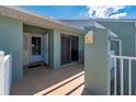 A front porch featuring a storm door, outside lantern, beige painted concrete, and white railings at 1408 San Cristobal Ave # 4, Punta Gorda, FL 33983