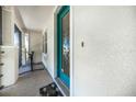 Welcoming front entrance with a teal door, textured walls, and a cozy welcome mat at 17408 Malarky Ln, Punta Gorda, FL 33955
