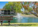 Scenic pond view with a fountain and a bench in a well-maintained community at 19505 Quesada Ave # F103, Port Charlotte, FL 33948