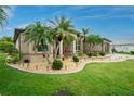 Inviting home exterior with lush tropical landscaping, accent lighting, and a well-maintained lawn at 21 Manizaks Ave, Punta Gorda, FL 33983