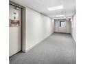 Well-lit condo hallway with neutral carpet and access to unit doors at 2300 Aaron St # 106, Port Charlotte, FL 33952