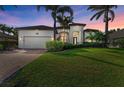 Beautiful home exterior featuring a well-manicured lawn, lush landscaping, and a paved driveway at 333 Santander Ct, Punta Gorda, FL 33950