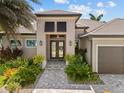 Elegant front entrance with double doors, well-manicured landscaping, and paver walkway at 3335 Grenada Ct, Punta Gorda, FL 33950
