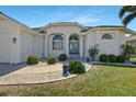Charming home exterior with landscaped garden, inviting walkway, and double door entry at 609 Macedonia Dr, Punta Gorda, FL 33950