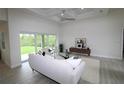 Bright living room featuring a cozy seating area, stylish decor, and sliding glass doors with backyard views at 9529 Calumet Blvd, Port Charlotte, FL 33981