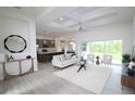 Open-concept living room with coffered ceilings, wood-look tile flooring, and sliding glass doors to enjoy the view at 9529 Calumet Blvd, Port Charlotte, FL 33981
