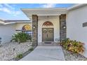 Inviting front entrance with decorative stone pillars and meticulously maintained landscaping at 1068 Harbour Cape Pl, Punta Gorda, FL 33983