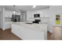 Well-lit kitchen featuring stainless steel appliances, white cabinets, and a spacious island at 18124 Goliad Ave, Port Charlotte, FL 33954