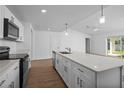 Bright, open kitchen featuring a large island, white cabinets, and stainless steel appliances at 18124 Goliad Ave, Port Charlotte, FL 33954