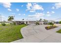 Charming single-story home with a wide driveway, two-car garage, and well-maintained lawn, exuding curb appeal and comfort at 21194 Edgewater Dr, Port Charlotte, FL 33952