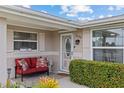Inviting front porch with cozy seating, lush plants, and a welcoming front door at 21194 Edgewater Dr, Port Charlotte, FL 33952
