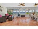 Bright sunroom with tile floors, comfortable seating, and expansive water views through large windows at 2308 Harbour Dr, Punta Gorda, FL 33983