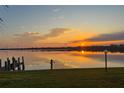 Stunning water view at sunset with reflections on the water, dock and grassy foreground at 2308 Harbour Dr, Punta Gorda, FL 33983