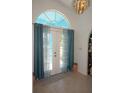 Inviting foyer featuring a tiled floor and double doors with decorative curtains at 25472 Tevesine Ct, Punta Gorda, FL 33983