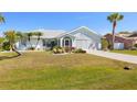 Well-maintained home with lush green lawn, mature palm trees, and colorful landscaping in front at 25730 Deep Creek Blvd, Punta Gorda, FL 33983