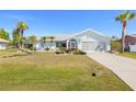 Inviting home featuring verdant lawn, mature palms and vibrant front garden landscape at 25730 Deep Creek Blvd, Punta Gorda, FL 33983