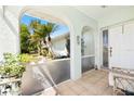 Cozy front porch featuring tiled floor, plants, and an arched entrance that provides curb appeal at 25730 Deep Creek Blvd, Punta Gorda, FL 33983