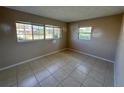 A bedroom featuring tile flooring and a large window, providing a bright and airy space at 30147 Holly Rd, Punta Gorda, FL 33982