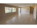 A living room featuring tile flooring, a large window, and an entrance door, providing a bright and airy space at 30147 Holly Rd, Punta Gorda, FL 33982