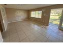 A living room featuring tile flooring, a large window, and an entrance door, providing a bright and airy space at 30147 Holly Rd, Punta Gorda, FL 33982