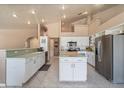 Spacious kitchen featuring white cabinetry, stainless steel appliances, tile floors, and a center island at 4951 Cypress Grove Cir, Punta Gorda, FL 33982