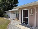 Inviting front entrance with a screened door and decorative landscaping at 594 W Tarpon Nw Blvd, Port Charlotte, FL 33952