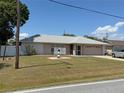 Charming single-story home with well-maintained lawn, a light house decoration, and a two car garage at 594 W Tarpon Nw Blvd, Port Charlotte, FL 33952
