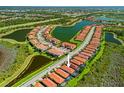 Aerial view of a vibrant community surrounded by serene lakes and lush green spaces at 10357 Crooked Creek Dr, Venice, FL 34293