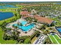 Aerial shot of a resort-style pool, clubhouse, and golf course within a luxurious community at 10357 Crooked Creek Dr, Venice, FL 34293