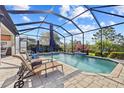 Screened-in pool area with comfortable lounge chairs and a serene waterfall feature at 10357 Crooked Creek Dr, Venice, FL 34293