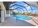 Enclosed pool area with a sparkling in-ground pool, patio, and view of the canal at 122 Colonial Se St, Port Charlotte, FL 33952
