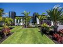 Beautifully landscaped front yard with vibrant plants and meticulously maintained lawn leading to the modern home's entrance at 1230 Royal Tern Dr, Punta Gorda, FL 33950