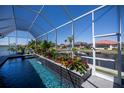 Screened in pool area boasting canal views and lush landscaping in a private backyard setting at 1230 Royal Tern Dr, Punta Gorda, FL 33950
