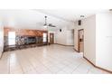 Spacious living room with stone fireplace and white tiled flooring throughout at 16249 Ashland Ave, Port Charlotte, FL 33954